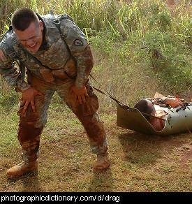 Photo of a soldier dragging a wounded comrade