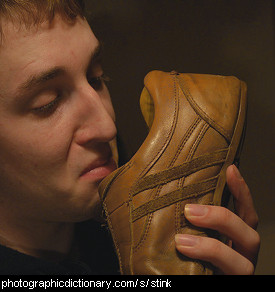 Photo of a man sniffing some shoes